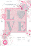 This image shows a romantic anniversary card that feels as tender and thoughtful as a hand-tied arrangement from a trusted local florist. The background is a soft, powdery pink, setting a serene stage for the raised LOVE at the centre, each letter coated in a fine, shimmering glitter. The shimmer blends blush pink, pearly white, and delicate silver, creating an effect reminiscent of candlelight reflecting off glass vases in a Kensington flower shop. Surrounding the word are gentle sprays of illustrated blossoms and airy leaves, their shapes flowing outward like the natural arch of a carefully arranged bouquet. The flowers are stylised but unmistakably romantic, washed in pastel pinks, ivory, and muted lilac, with subtle shading that suggests depth and softness. Slender vines and scroll-like flourishes curl around the blooms, adding a whimsical rhythm to the design. Tiny accents, perhaps dots or miniature petals, glint in silver, giving the whole card a sense of light motion, as though a soft breeze from Kensington Gardens were passing across its surface. At the bottom and along the side, an elegant script carries anniversary sentiments such as I love you today and always, set in a refined yet understated style. The overall mood is intimate, peaceful, and deeply affectionate, like a cherished card tucked beside a vase of fresh anniversary flowers delivered to a townhouse or apartment somewhere off High Street Kensington, capturing years of shared memories in one beautifully detailed design.